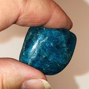 Puede incluir: Una piedra lisa de color azul verdoso oscuro, de forma ligeramente irregular.