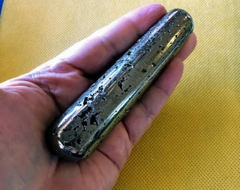 May include: A smooth, dark gray, cylindrical shaped stone with a rough, textured surface. The stone is about 6 inches long and 1.5 inches wide.