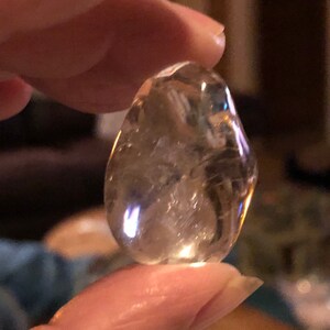 May include: A clear, faceted, teardrop-shaped crystal with a light golden hue.