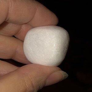 May include: A smooth, white, round stone with a slightly irregular shape.