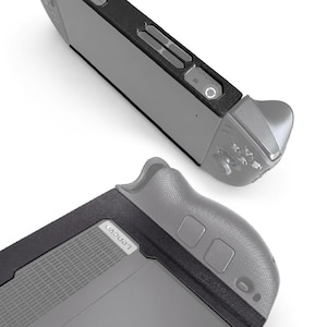 May include: A handheld gaming console featuring a silver body with black trim and grips. The device displays the Lenovo logo on the back and the word LEGION printed in large letters. The top edge shows various buttons, ports, and a power indicator light.