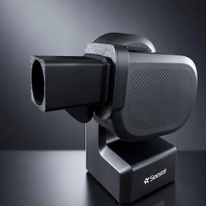 May include: A black, modern device with a rectangular barrel-like extension and a rounded body. The device is mounted on a base, with the word "Seestar" and a star logo printed on the base. The body has a textured surface.