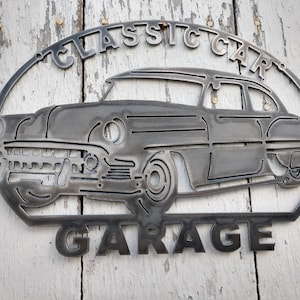 Peut inclure: Une plaque en métal avec la silhouette d'une voiture classique et les mots "Classic Car Garage".