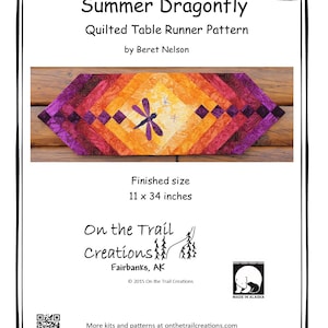 Puede incluir: Un patrón de camino de mesa acolchado con un diseño de libélula en tonos de morado, naranja y amarillo. El patrón se titula "Summer Dragonfly" y es de Beret Nelson. El tamaño terminado es de 28 x 86 cm.