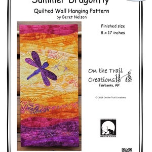 May include: A quilted wall hanging pattern featuring a purple dragonfly on a colorful background. The pattern is titled "Summer Dragonfly" and is by Beret Nelson. The finished size is 8 x 17 inches.