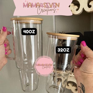 May include: Two clear glass tumblers with bamboo lids and handles. One tumbler is labeled "40oz" and the other "32oz". The tumblers are from "Mama4Seven Creations".