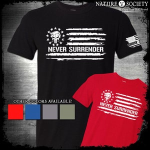 May include: Black t-shirt with a distressed American flag design featuring a skull with a bandana and the words "Never Surrender". The shirt is available in other colors: red, blue, gray, and green.