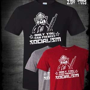 May include: Black, grey, and red t-shirts featuring a cartoon bear wearing a ranger hat and holding a rifle. The text on the shirts reads "Only You Can Prevent Socialism".