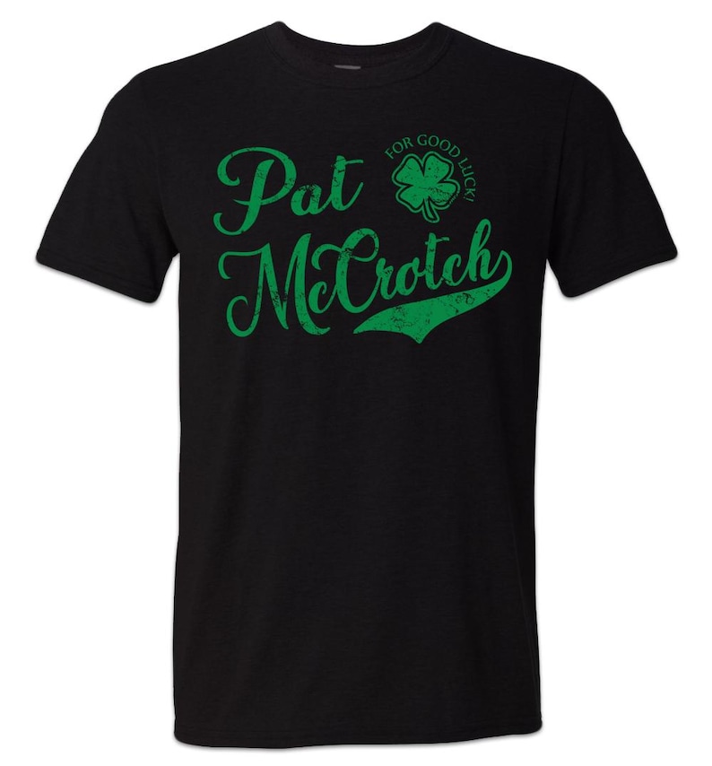 May include: Black t-shirt with green text that reads "Pat McCroch" and a green four-leaf clover with the text "For Good Luck!" above it.