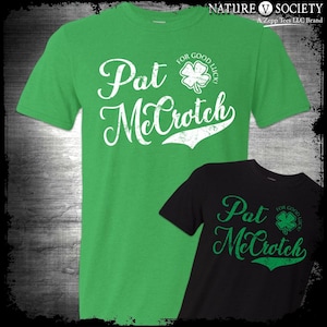 May include: Two green and black t-shirts with a white graphic that says "Pat Mcrotch" and a four-leaf clover. The text says "For Good Luck" above the clover on the green shirt. The text says "For Good Luck" to the right of the clover on the black shirt.