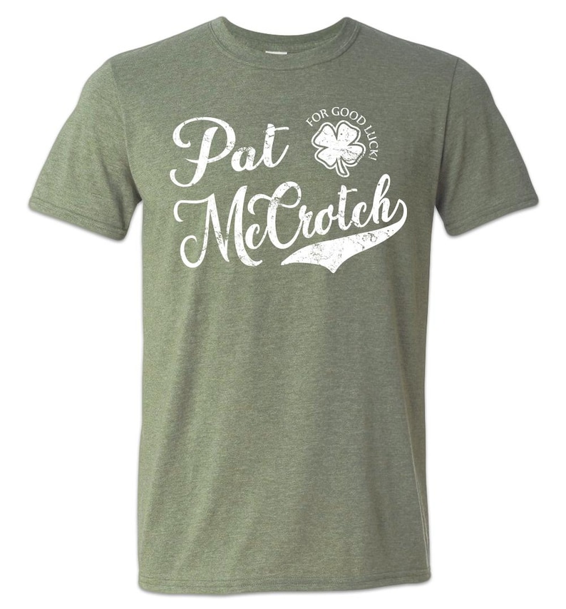 May include: A green t-shirt with a white distressed graphic that says "Pat McCroch" with a shamrock and the text "For Good Luck!" above the name.
