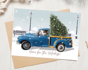 May include: A blue pickup truck with a Christmas tree in the back driving through a snowy scene. The truck has a yellow bed and a driver in the cab. The text "Home for the Holidays!" is printed below the truck.