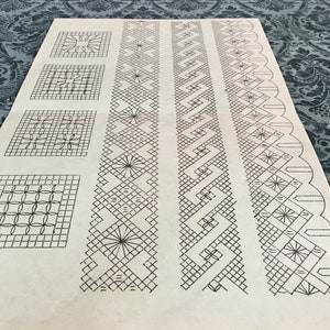 May include: A sheet of paper with various black and white lace patterns. The designs include square motifs and elongated bands with geometric and floral elements. The paper has a slightly aged appearance.