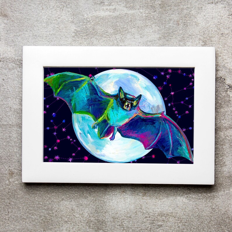 Puede incluir: Una pintura enmarcada de un murci&eacute;lago azul y verde volando frente a una luna llena con un fondo de cielo nocturno estrellado.