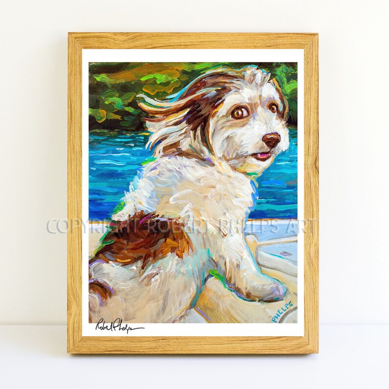 May include: A painting of a white and brown dog with its tongue sticking out. The dog is sitting on a boat with blue water in the background. The painting is signed "Robert Phelps" in the bottom left corner and "PHELPS" in the bottom right corner.
