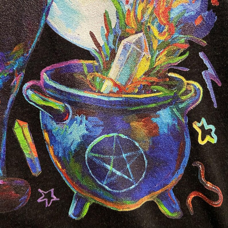 May include: A black cauldron with a pentagram design, filled with colorful plants and a crystal. The cauldron is surrounded by stars and other magical symbols.
