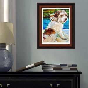 May include: A painting of a white and brown dog with its tongue sticking out. The dog is in a boat and the water is blue. The painting is framed in a brown frame.