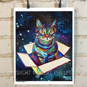 May include: A colorful, abstract painting of a cat sitting in a box against a dark blue, starry background. The cat's fur is painted in shades of blue, green, yellow, and orange. The box is white with a yellow interior. The painting is signed "Robert Phelps" in the bottom right corner.
