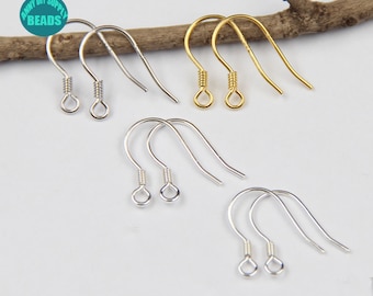May include: A set of six earring hooks, three silver and three gold, displayed on a wooden branch. The hooks are made of metal and have a simple, elegant design.