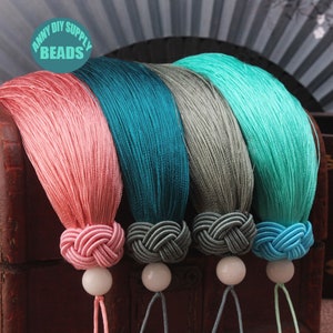 Peut inclure: Quatre glands de couleur rose, bleu sarcelle, gris et bleu clair avec des perles blanches à l'extrémité de chaque gland. Les glands sont noués en haut et ont une longue frange fluide.