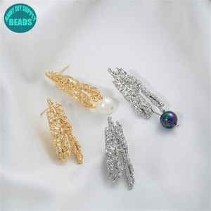Pode incluir: Três pares de brincos de ouro e prata com designs texturizados. Cada brinco tem uma pérola ou uma pérola iridescente pendurada.