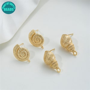 Może przedstawiać: Trzy złote, muszelkowe zapięcia do kolczyków. Dwa są spiralne, a jeden ma bardziej tradycyjny kształt muszli.