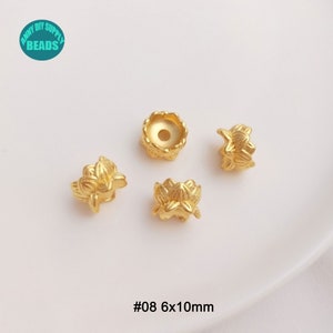 May include: Gold-colored lotus flower-shaped beads. The beads are made of metal and have a detailed floral design. The image includes four beads, with the text "#08 6x10mm" at the bottom. The beads are approximately 0.24 x 0.39 inches.