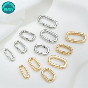 Könnte beinhalten: Sortiment an ovalen Verschlüssen in Silber und Gold mit Federverschluss. Die Verschlüsse sind perfekt für die Schmuckherstellung, die Taschenherstellung und andere Bastelprojekte.