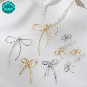 Op de afbeelding: Een set gouden en zilveren sieradenbevestigingen in de vorm van een strik. De bevestigingen zijn gemaakt van gedraaid draad en hebben een lus aan de bovenkant om aan een ketting of ander sieraad te bevestigen. De bevestigingen zijn perfect voor het maken van oorbellen, kettingen of armbanden.