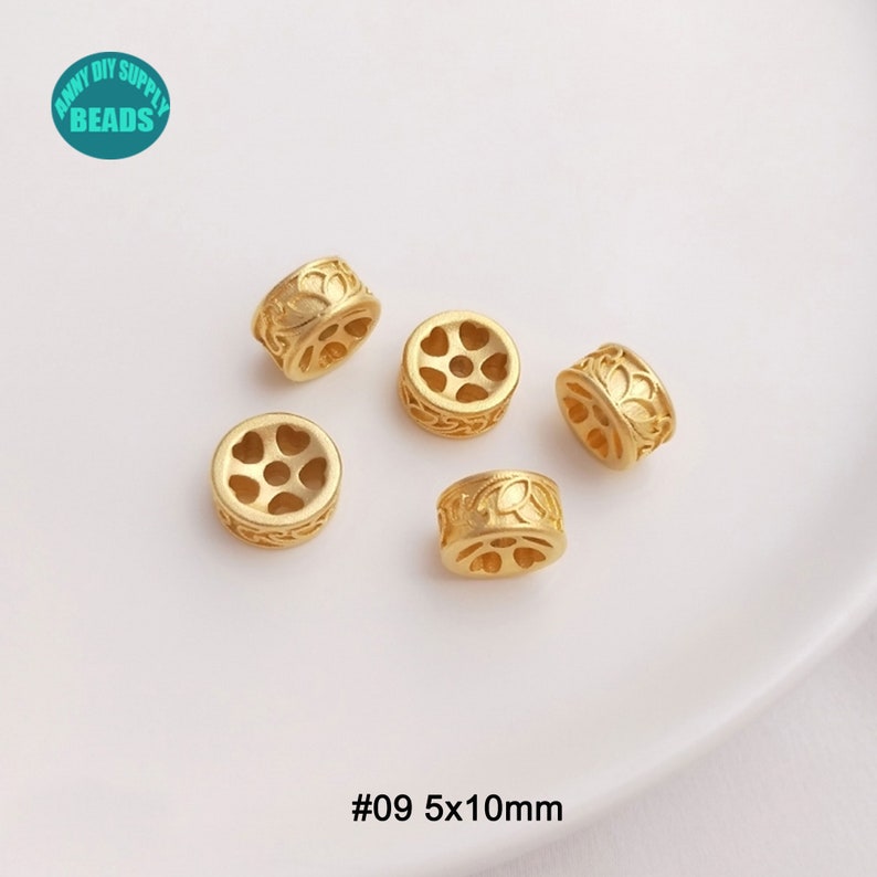 May include: Gold-colored metal beads with floral and heart-shaped cutouts. The beads are cylindrical, measuring 5mm x 10mm. The image includes the text "#09 5x10mm" and a logo that says "Anny DIY Supply Beads".