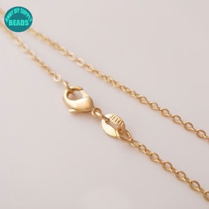 May include: A gold chain necklace with a lobster clasp and a small tag that says "JFLX".