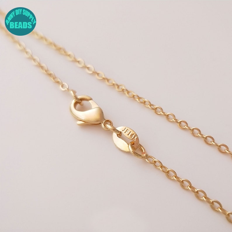 May include: A gold chain necklace with a lobster clasp and a small tag that says "JFLX".