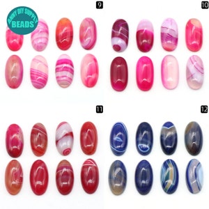 Pu&ograve; includere: Assortimento di 12 cabochon ovali, in agata rosa e blu con bande bianche e grigie. I cabochon sono disposti in quattro file di tre, etichettati 9, 10, 11 e 12.