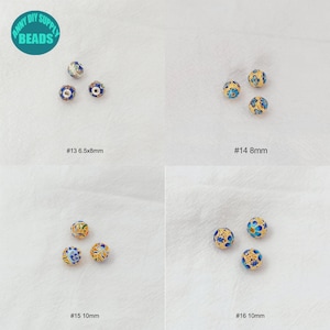 K&ouml;nnte beinhalten: Vier S&auml;tze blauer und goldener Emailleperlen mit Blumenmustern. Die Perlen sind in Gruppen von drei angeordnet, wobei jede Gruppe mit einer Nummer und einer Gr&ouml;&szlig;e in Millimetern gekennzeichnet ist. #13 6,5x8mm, #14 8mm, #15 10mm, #16 10mm.
