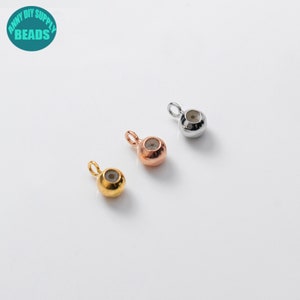 May include: Three metal bead caps with a loop for attaching to jewellery. The bead caps are silver, gold, and rose gold.