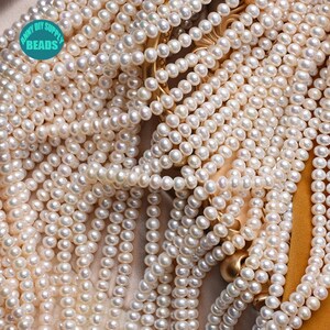 May include: A close-up of a large quantity of white pearl beads. The beads are round and smooth, and they are arranged in a random pattern. The beads are perfect for making jewelry or other crafts.