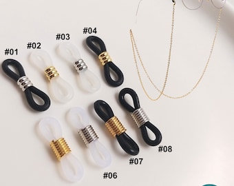 May include: Ten different styles of black, white, and clear plastic eyeglass chain holders with gold and silver metal accents. The holders are numbered 01 through 08.