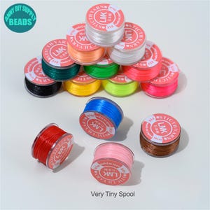 May include: A collection of colorful spools of thread, including white, orange, green, yellow, pink, and blue. Each spool is labeled with Japanese text and the words "STICTH YARN". The text "Very Tiny Spool" is also visible.