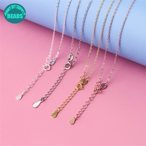 May include: Four silver chains with lobster clasps and extender chains. The chains are in different finishes: silver, gold, rose gold, and black.
