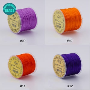 May include: Four spools of elastic string in different colours: purple, orange, orange, and purple. Each spool has a label that reads "ポリウレタン 100% 日本水晶线" and a number: #09, #10, #11, and #12.