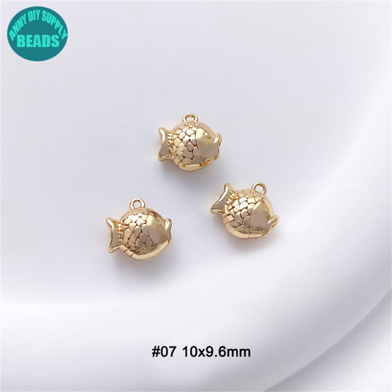 Puede incluir: Tres abalorios de pescado de color dorado con superficie texturizada. Los abalorios miden aproximadamente 10 mm por 9,6 mm. #07 10x9,6 mm