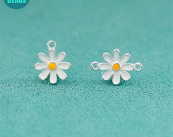 May include: Two daisy-shaped charms with white petals, yellow centers, and silver-colored metal edging. Each charm has a loop for attaching to jewelry. The background is a solid teal color, and the text "ANNY DIY SUPPLY BEADS" is in a circle in the upper left corner.