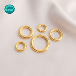 Puede incluir: Cinco anillos de salto dorados de diferentes tamaños. Los anillos son lisos y tienen un acabado mate.