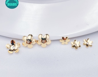 May include: Five gold flower-shaped bead caps. The caps have a small hole in the center for stringing beads.