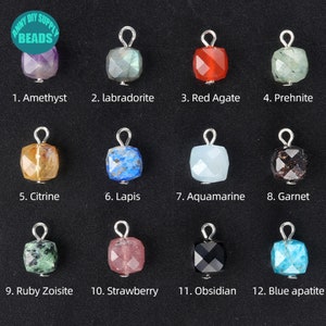 May include: Twelve different gemstone beads with silver jump rings. The beads are in a grid pattern and are labeled with their names: Amethyst, Labradorite, Red Agate, Prehnite, Citrine, Lapis, Aquamarine, Garnet, Ruby Zoisite, Strawberry, Obsidian, and Blue apatite.