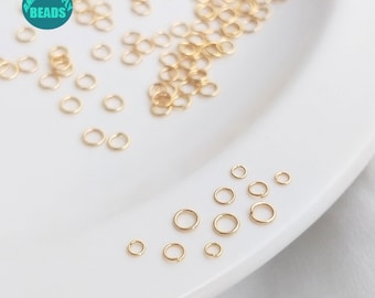 May include: A collection of small, gold-colored jump rings of varying sizes, scattered on a white surface. The rings are open, ready for use in jewelry making or other crafts. The image includes a logo that says "Anny DIY Supply Beads."