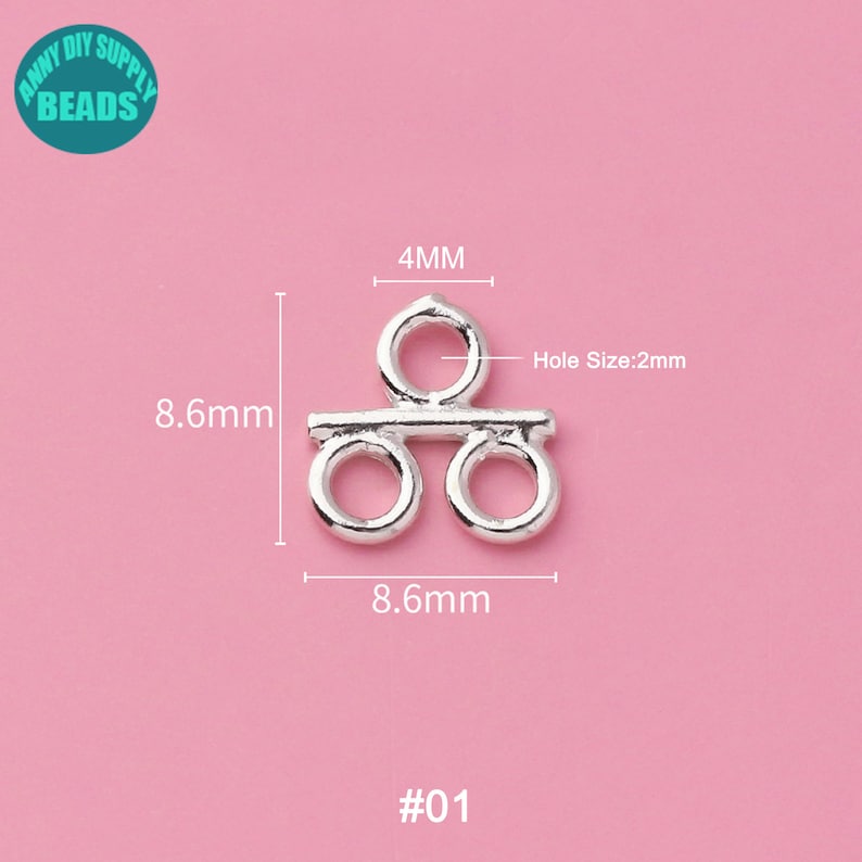 May include: Silver-toned metal connector with two loops and a bar in the middle. The connector measures 8.6 mm wide and 4 mm high. The hole size is 2 mm. #01