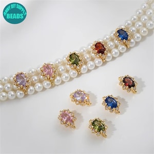 Peut inclure: Un ensemble de connecteurs ovales en or avec des pierres précieuses de différentes couleurs, serties de cristaux. Les connecteurs sont présentés sur un collier de perles.