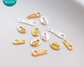 Puede incluir: Surtido de etiquetas metálicas doradas y plateadas con varias marcas, incluyendo "14K", "925" y "10K", aptas para la elaboración de joyas.