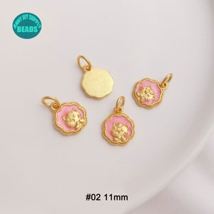 May include: Gold-colored metal pendants with a pink enamel tiger design. The pendants are approximately 0.43 inches in diameter and have a loop for attaching to jewelry. The image also includes the text "#02 11mm".